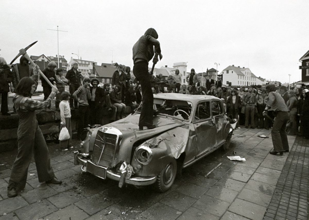 Rúrí, Gullinn bíll, 1974. Gjörninginn flutti Rúrí á sýningunni "Höggmyndir á þjóðhátíðarári, útisýning Myndhöggvarafélagsins í Reykjavík", á Lækjartorgi, árið 1974. Aðstoðarmenn við flutning: B. Gylfi Snorrason og óþekktir þátttakendur úr hópi áhorfanda. Ljósmynd: Ólafur Lárusson.