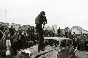 Rúrí, Gullinn bíll, 1974. Gjörninginn flutti Rúrí á sýningunni "Höggmyndir á þjóðhátíðarári, útisýning Myndhöggvarafélagsins í Reykjavík", á Lækjartorgi, árið 1974. Aðstoðarmenn við flutning: B. Gylfi Snorrason og óþekktir þátttakendur úr hópi áhorfanda. Ljósmynd: Ólafur Lárusson.